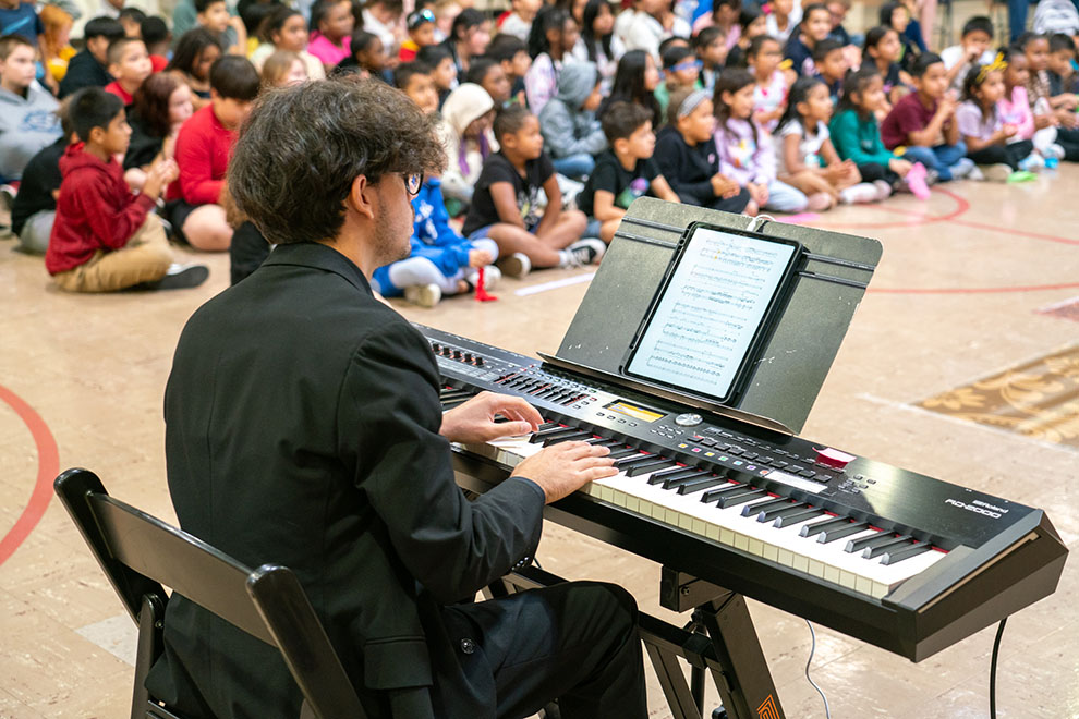 Resident Artist Matteo Generani playing piano for a school performance of The Haberdasher Prince, photo by Andrew Schwartz